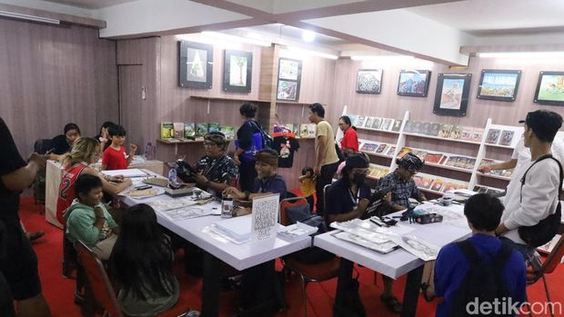 Suasana keramaian pengunjung di PKB 2025 yang menunggu giliran disketsa wajahnya oleh empat seniman karikatur di Art Center Denpasar, Sabtu (5/7/2025). (Aryo Mahendro/detikBali)