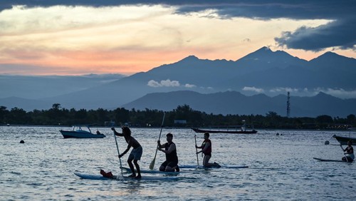 Sejumlah wisatawan asing bermain paddel board atau papan dayung di kawasan taman wisata perairan Gili Matra di Gili Trawangan, Desa Gili Indah, Kecamatan Pemenang, Tanjung, Lombok Utara, NTB, Sabtu (5/7/2025). Kawasan konservasi nasional taman wisata perairan (TWP) Gili Air, Gili Meno dan Gili Trawangan atau yang lebih dikenal dengan Gili Matra memiliki potensi alam bahari yang indah, antara lain hamparan pasir putih dan lautnya yang jernih serta terumbu karang  dengan ikan yang beranekaragam yamg mampu menarik wisatawan baik lokal maupun mancanegara.
ANTARA FOTO/Ahmad Subaidi