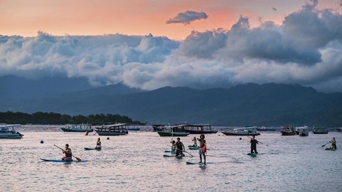 Sejumlah wisatawan asing bermain paddel board atau papan dayung di kawasan taman wisata perairan Gili Matra di Gili Trawangan, Desa Gili Indah, Kecamatan Pemenang, Tanjung, Lombok Utara, NTB, Sabtu (5/7/2025). Kawasan konservasi nasional taman wisata perairan (TWP) Gili Air, Gili Meno dan Gili Trawangan atau yang lebih dikenal dengan Gili Matra memiliki potensi alam bahari yang indah, antara lain hamparan pasir putih dan lautnya yang jernih serta terumbu karang  dengan ikan yang beranekaragam yamg mampu menarik wisatawan baik lokal maupun mancanegara.
ANTARA FOTO/Ahmad Subaidi