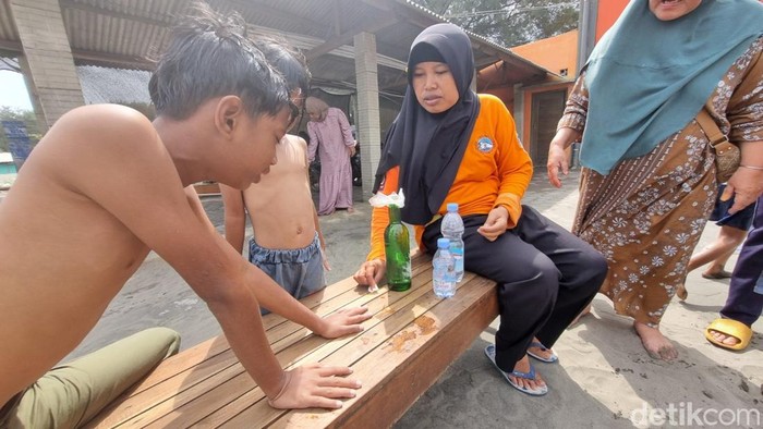 Tim SAR Parangtritis memberikan pertolongan ke anak korban sengatan ubur-ubur, Sabtu (5/7/2025).