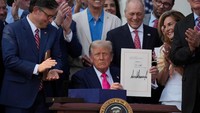 Trump menggunakan palu simbolik seusai menandatangani dokumen tersebut, menegaskan pentingnya undang-undang yang diklaim akan mereformasi sistem pajak sekaligus memastikan pendanaan program-program federal secara berkelanjutan. REUTERS/Leah Millis 