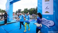 Peserta Nobel Run 2025 melintasi garis finish setelah menuntaskan jarak 5 km dan 10 km dalam mengikuti mengikuti Nobel Run: Berlari Bersama Teman Tuli di Jakarta, Minggu (6/7/2025).