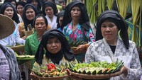 Sejumlah warga membawa bubur suro dalam kirab budaya memperingati 10 Muharram di Desa Wisata Bandung, Banjar, Pandeglang, Banten, Minggu (6/7/2025). ANTARA FOTO/Angga Budhiyanto