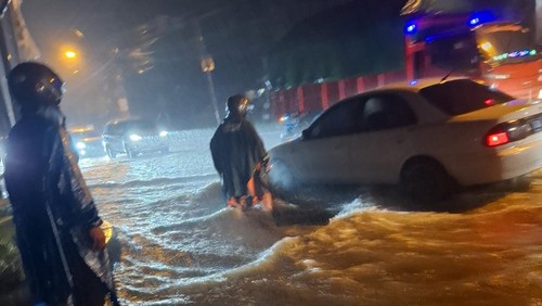 Air hujan yang tinggi menggenang hingga sulitkan pengendara melintas di Jalan Raya Blahkiuh, Badung, Minggu malam. (IST)