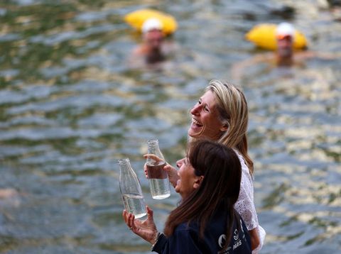 Menteri Olahraga, Pemuda, dan Kehidupan Masyarakat Prancis Marie Barsacq dan Wali Kota Paris Anne Hidalgo memegang botol berisi air dari Sungai Seine sambil berdiri di tepian di lokasi Bras Marie, dibuka untuk perenang yang menandai sesi pemandian umum pertama di jalur air bersejarah ibu kota tersebut, di Paris, Prancis, 5 Juli 2025. (REUTERS/Abdul Saboor)