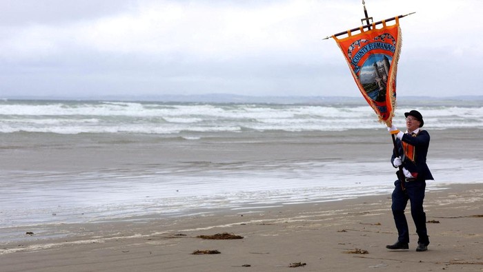 Anggota Orde Oranye berpawai di pantai Rossnowlagh, Irlandia. Tradisi tahunan ini digelar jelang peringatan kemenangan Raja William.