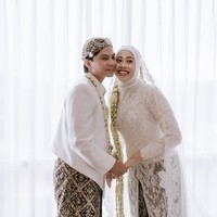 Busana pengantin Jawa yang didominasi warna putih menjadi pilihan kedua sejoli ini untuk hari bahagia mereka. Biasa bergaya sporty di lapangan, Megawati yang mendapat julukan Megatron itu tampil beda dengan kebaya panjang penuh detail brokat yang  menawan. (Foto: Instagram/@estoria_photography)