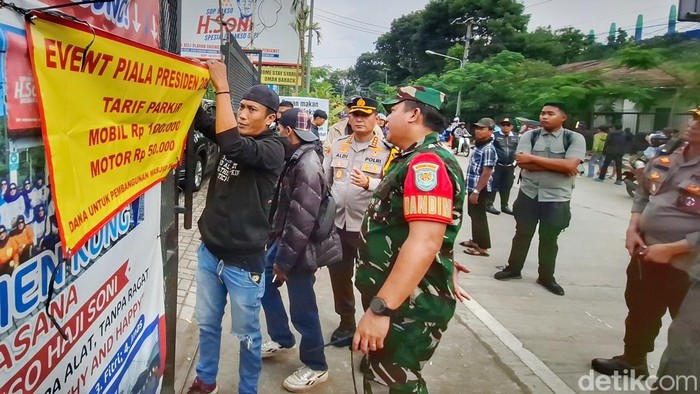 Polisi dan TNI menertibkan parkir liar dengan harga tak wajar di sekitar Stadion Si Jalak Harupat.