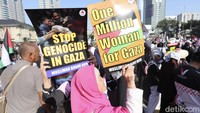 Massa aksi mengenakan pakaian serba hitam dan mengenakan syal Palestina sebagai simbol dukungan.