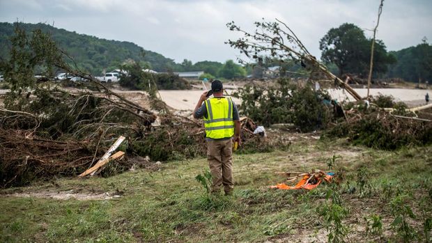 Seorang relawan penyelamat berbicara di telepon setelah banjir mematikan di Kerr County, Texas, AS, 5 Juli 2025. (REUTERS/Sergio Flores)