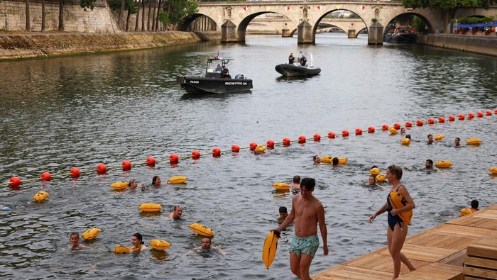 Berenang di Sungai Seine Dekat Eiffel Kini Jadi Kenyataan People swim in the River Seine, with the Eiffel tower in the background, at the Grenelle site, opened to swimmers marking the first public bathing session in the capital's historic waterway, in Paris, France, July 5, 2025. REUTERS/Abdul Saboor      TPX IMAGES OF THE DAY