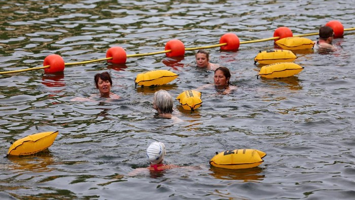 Berenang di Sungai Seine Dekat Eiffel Kini Jadi Kenyataan People swim in the River Seine, with the Eiffel tower in the background, at the Grenelle site, opened to swimmers marking the first public bathing session in the capital's historic waterway, in Paris, France, July 5, 2025. REUTERS/Abdul Saboor      TPX IMAGES OF THE DAY