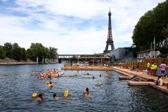 People swim in the River Seine, with the Eiffel tower in the background, at the Grenelle site, opened to swimmers marking the first public bathing session in the capitals historic waterway, in Paris, France, July 5, 2025. REUTERS/Abdul Saboor      TPX IMAGES OF THE DAY