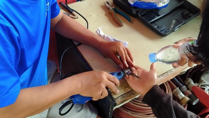 Petugas saat mengevakuasi cincin yang nyangkut di jari.