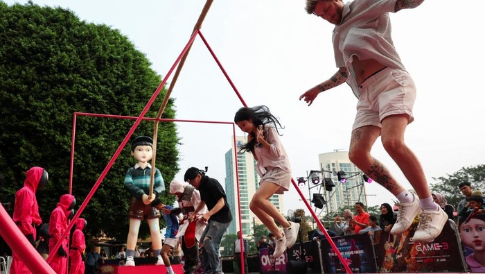People play a Jump Rope game with giant dolls named 'Young-hee' and 'Chul-su' from Netflix series 'Squid Game' during a promotional event of 'Squid Game 3' final season at Plaza Senayan shopping mall in Jakarta, Indonesia, July 4, 2025. REUTERS/Ajeng Dinar Ulfiana