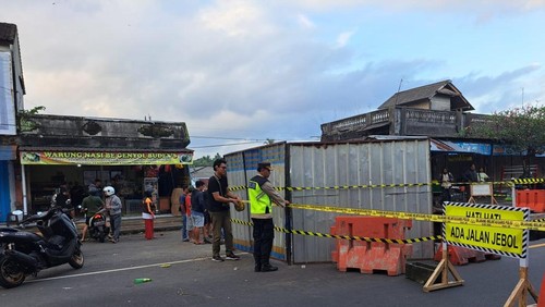 Satlantas Polres Tabanan mengalihkan arus lalulintas akibat jalan amblas di Jalur Denpasar-Gilimanuk di depan Pasar Bajera, Kecamatan Selemadeg, Senin (7/7/2025).