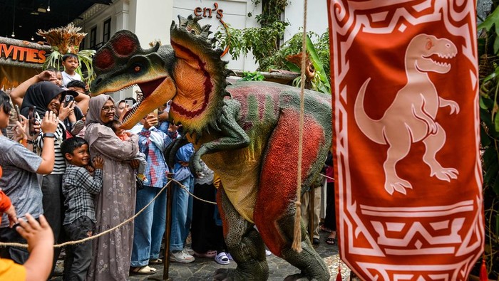 Jurassic Java Bandung Bikin Liburan Makin Seru dengan Atraksi Dinosaurus Petugas mengenakan kostum dinosaurus jenis Dilophosaurus menyapa pengunjung wahana Jurrasic Java di pusat perbelanjaan Paris Van Java, Bandung, Jawa Barat, Senin (7/7/2025). Untuk memeriahkan liburan sekolah, pusat perbelanjaan Paris Van Java menggelar wahana Jurassic Java yang menampilkan dua ekor
