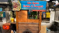 Mie Ayam Pak Loso di Menteng dikenal lewat gerobaknya yang mencolok dengan spanduk biru. Letaknya strategis di seberang Polsek Menteng, Jakarta Pusat. Foto: detikFood