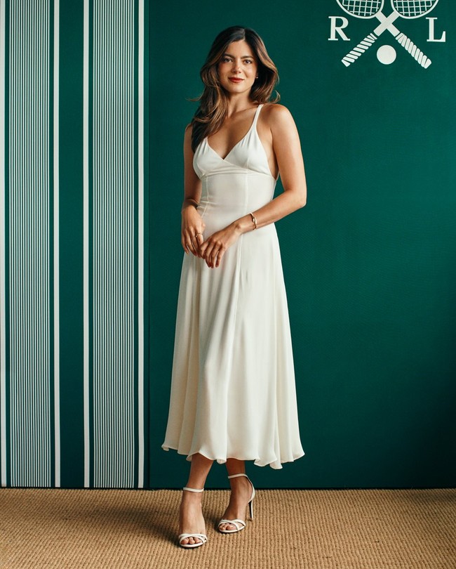 Monica Barbaro menawan dengan dress yang menampilkan tubuh langsingnya. Busana wanita 35 tahun asal AS ini padukan dengan strappy heels putih dan hand bag cokelat.Foto: Instagram @ralphlauren