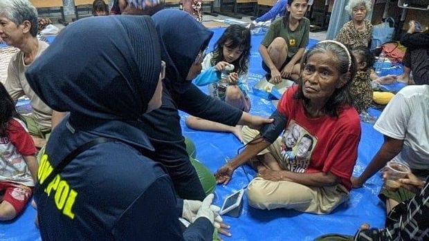 Polisi turun membantu penduduk terdampak banjir di Kebon Pala, Jakarta Timur, Senin (7/7/2025). Polisi mendirikan dapur lapangan hingga pelayanan kesehatan kepada penduduk tedampak banjir.