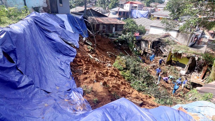 Puncak Bogor Diterjang Longsor, Tiga Warga Tewas dan Puluhan Rumah Rusak Petugas membersihkan material tanah longsor yang menimpa rumah di Megamendung, Puncak, Kabupaten Bogor, Jawa Barat, Senin (7/7/2025). Berdasarkan data BPBD Kabupaten Bogor bencana banjir dan tanah longsor di Kawasan Puncak Bogor pada Sabtu (5/7) malam itu menyebabkan tiga orang meninggal dunia, seorang mengalami luka ringan dan seorang masih dalam pencarian serta mengakibatkan tujuh unit rumah rusak ringan, 13 unit rumah rusak sedang dan empat unit rumah rusak berat. ANTARA FOTO/Yulius Satria Wijaya/nym.