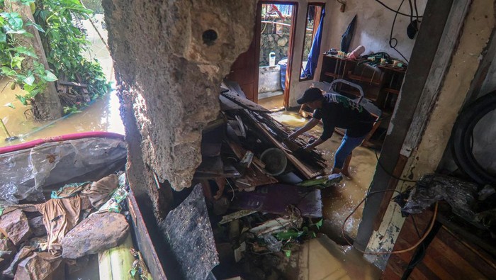 Petugas membersihkan material tanah longsor yang menimpa rumah di Megamendung, Puncak, Kabupaten Bogor, Jawa Barat, Senin (7/7/2025). Berdasarkan data BPBD Kabupaten Bogor bencana banjir dan tanah longsor di Kawasan Puncak Bogor pada Sabtu (5/7) malam itu menyebabkan tiga orang meninggal dunia, seorang mengalami luka ringan dan seorang masih dalam pencarian serta mengakibatkan tujuh unit rumah rusak ringan, 13 unit rumah rusak sedang dan empat unit rumah rusak berat.  ANTARA FOTO/Yulius Satria Wijaya/nym.