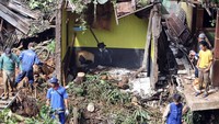 Petugas membersihkan material tanah longsor yang menimpa rumah. Longsor mengakibatkan tujuh unit rumah rusak ringan, 13 unit rumah rusak sedang dan empat unit rumah rusak berat. Foto: ANTARA FOTO/Yulius Satria Wijaya