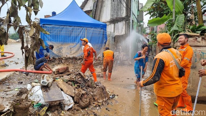 Suku Dinas (Sudin) Sumber Daya Air dan PPSU turun tangan membantu warga membersihkan sisa-sisa lumpur banjir rumah warga di Rawajati, Pancoran, Jaksel (Taufiq S/detikcom)