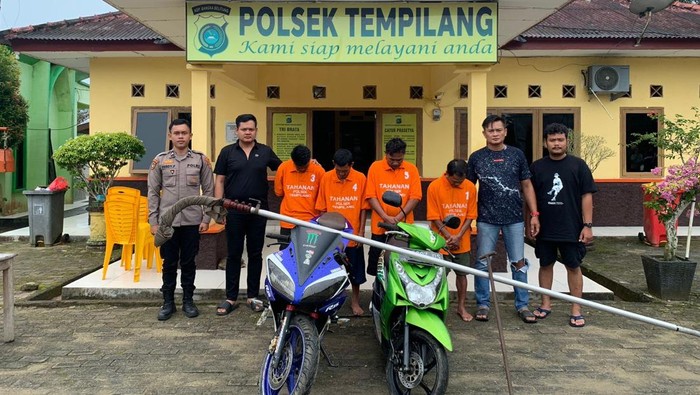Tersangka mengenakan baju tahanan dan barang bukti.
