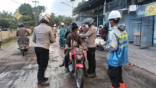 Tim medis Polda NTT saat membagi masker kepada warga yabg terdampak erupsi Gunung Lewotobi Laki-laki di Flores Timur, NTT, Senin (7/7/2025).