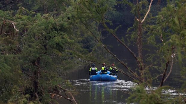 Tim penyelamat mendayung perahu karet saat mencari korban setelah banjir bandang di Kerrville, Texas, AS, Minggu (6/7/2025). (REUTERS/Marco Bello)