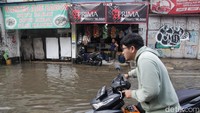 Warung Madura tetap buka melayani pembeli meski jalanan sekitar kebanjiran. Warung ini dikenal buka 24 jam tanpa mengenal waktu dan cuaca.