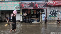 Warung Madura beroperasi di Jalan Ceger Raya, Tangerang Selatan, yang terpantau banjir hari Selasa (8/7/2025).