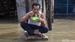 Aksi Santuy Bapak-bapak Makan Mie Instan di Tengah Banjir