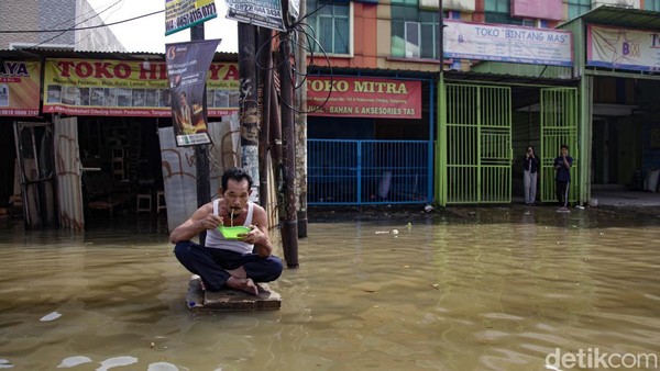 Aksi Santuy Bapak-bapak Makan Mie Instan di Tengah Banjir