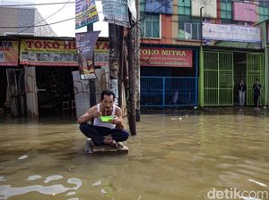 Aksi Santuy Bapak-bapak Makan Mie Instan di Tengah Banjir