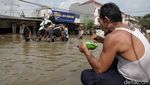 Aksi Santuy Bapak-bapak Makan Mie Instan di Tengah Banjir