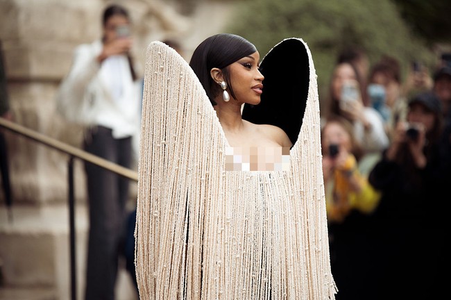 Gaun dilengkapi aksen bahu super besar yang dihiasi untaian manik-manik gading. Untaian manik-manik itu menjuntai hingga lutut, nyaris menutupi sarung tangan opera hitam yang melengkapi total look-nya. Foto: WireImage/Christian Vierig