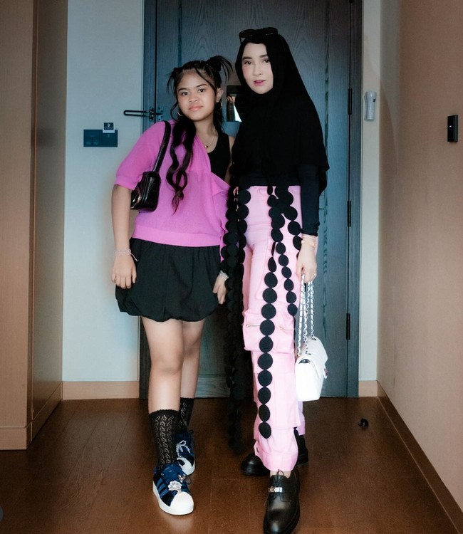 Shandy Purnamasari tak ketinggalan ikut menonton konser bersama putrinya. Shandy memilih memadukan atasan lengan panjang dan hijab hiitam dengan celana panjang kargo warna pink. Foto: Instagram