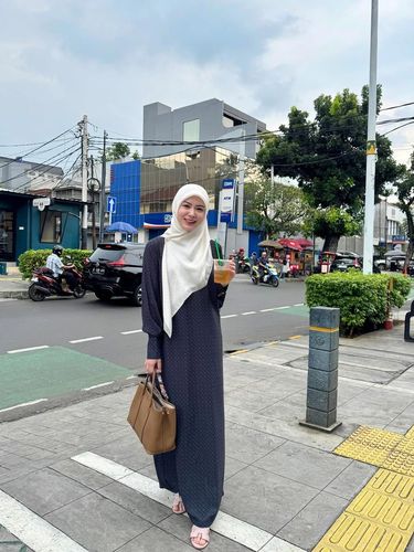 Gaya Ayana Moon pakai gamis warna navy dan hijab segi empat warna cream.