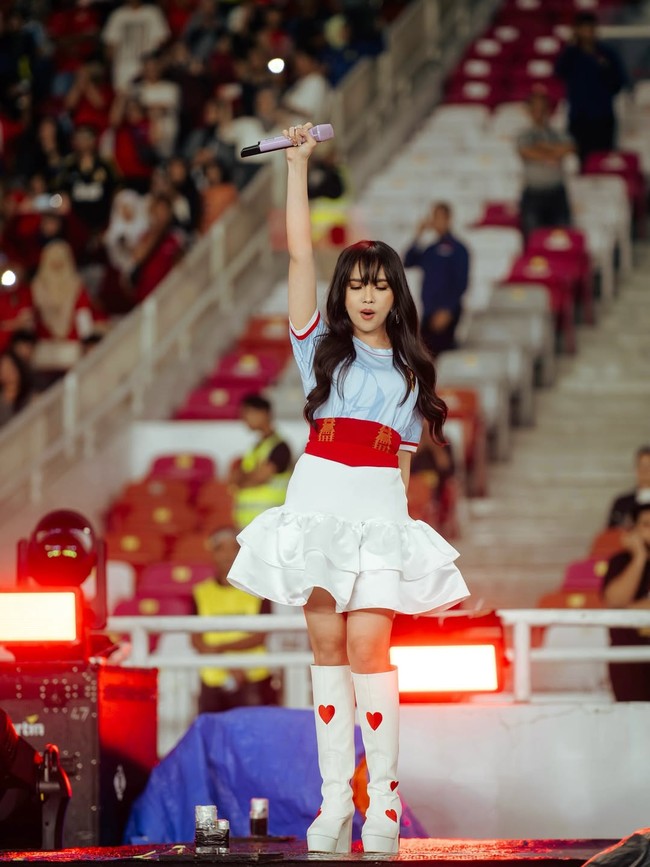 Lyodra tampil dengan gaya playful memakai jersey bola berwarna biru, mini dress putih dan boots motif hati. Mini dress yang dikenakannya merupakan rancangan desainer Jessie Gunawan. Foto: Dok. Instagram Lyodra, ViviThalib