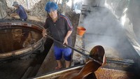 Pekerja memindahkan gula tebu masak ke tampi besar untuk proses pengeringan alami. Gula tradisional nonkristal atau biasa disebut gula garuk/awur untuk bahan baku kecap ataupun campuran bumbu petis. Foto: ANTARA FOTO/Destyan Sujarwoko