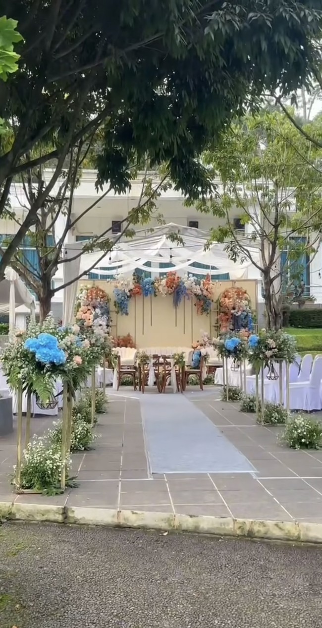 Digelar secara outdoor, pelaminan tampak cantik bertabur bunga warna warni. Didominasi warna kecoklatan, oranye, dan biru, dekorasi di pernikahan Gunawan dan Alya terlihat simpel. Foto: Instagram/@gunawandwicahyo13