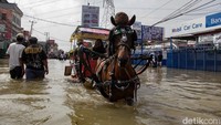 Delman masih terlihat melintasi genangan banjir di lokasi.