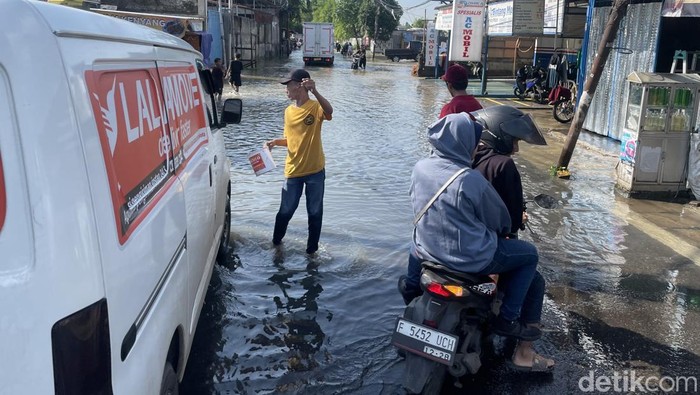 Jalan H Mansyur, Gondrong, Tangerang, macet parah imbas banjir, Selasa (8/7/2025). Sejumlah kendaraan memilih putar balik.