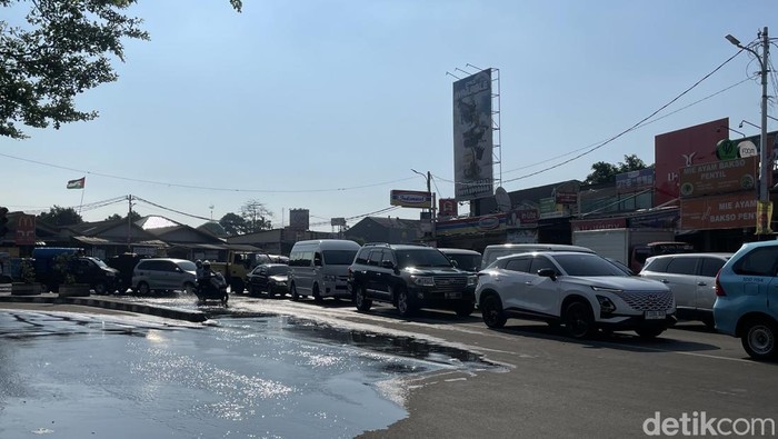 Jalan H Mansyur, Gondrong, Tangerang, macet parah imbas banjir, Selasa (8/7/2025). Sejumlah kendaraan memilih putar balik.