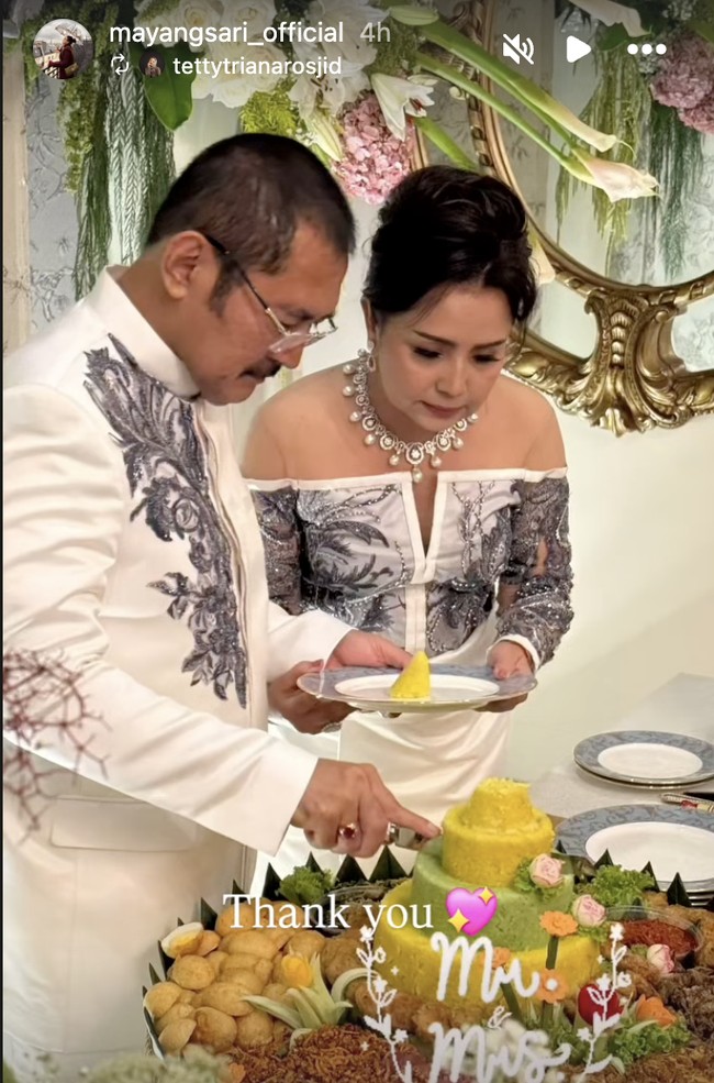 Dalam perayaan tersebut, keduanya tampil kompak dengan gaya couple bernuansa putih. Mayangsari mengenakan gaun off-shoulder dengan sentuhan brokat abu-abu yang anggun. Foto: dok. Instagram