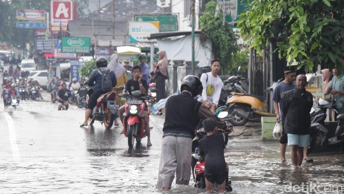 Pengendara menerobos banjir di Jalan Ceger Raya, Pondok Aren, Tangsel, Selasa (8/7/2025).