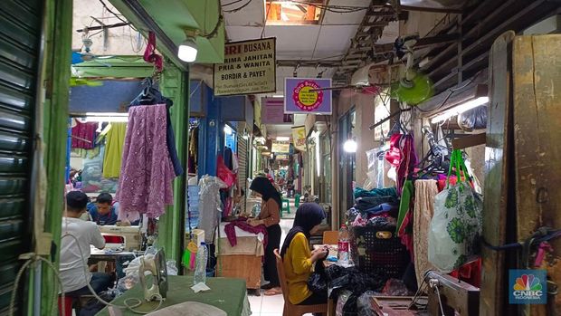 Penjahit tengah menyelesaikan pesanan pengguna di gerai Pasar Sunan Giri, Jakarta Timur, Selasa (8/7/2025). (librosfullgratis.com/Martyasari Rizky)