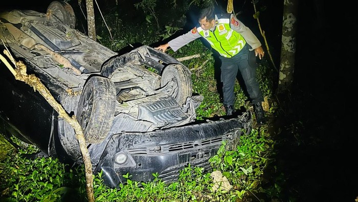 Polisi mengecek mobil yang terjun ke dasar jurang di Girimulyo, Kulon Progo, Senin (7/7/2025) malam.